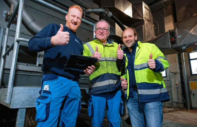 3 Mitarbeiter zeigen vor Bandtrockner den Daumen hoch