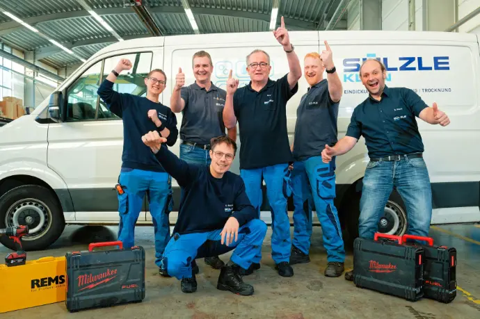 Gruppenfoto von Suelzle Klein Mitarbeiterinnen und Mitarbeitern vor Servicefahrzeug